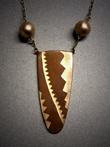 Chevrons; U shaped Copper pendant with 3 bronze inlaid chevrons of various sizes measuring 2h x 1 ¼w. Hangs on adjustable bronze chain embellished with a hollow bronze bead on each side of pendant.