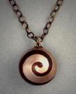 Spiral Sphere pendant of bronze with copper inlay spiral, measuring ¾ dia. and hangs on a bronze 18 to 23 adjustable length chain.