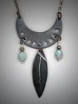Steel Crescent Pendant - Leaf ; L=  2 ½   W= 1 3/8;   Hand sculpted steel crescent pendant.  From the steel crescent hangs a 1 ½ steel leaf and flanked by two 6x9mm Labradorite gemstones and Pyrite beads.  Hangs on a 22 chain.