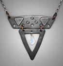 Steel Sm. V Pendant ; L=  1 3/4 ”   W= 1 7/8”;  Hand sculpted steel pendant.   Triangular shapes, 2 piece steel within which hangs a 5x7mm Fire Moonstone briolette gemstone.  Hangs on a 20” chain.