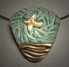 Bird in Flight-2;  Bronze pendant with bird flying over the ocean. Green patina. Pendant measures 11/2"w x 1 5/8h and hangs on 18 wrapped stainless steel.