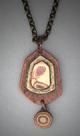 Hand sculpted antiqued copper pendant with a bronze and copper Mokume Gane center and with a 6mm. round Mokume Gane bead hanging below.  Hangs on a 22 antiqued bronze chain.  L= 1 1/8   W= 9/16.