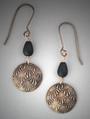 Hand-sculpted Bronze earrings.  A domed circle of bronze with V-lines pattern below an oval matt glass bead. L= 2 1/16 (including ear wire)  W= ¾
