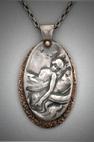 Oval pendant of bronze on copper; fine texture background; 1 x 2; chain 18with the image of a reclining woman; L= 2  W= 1.